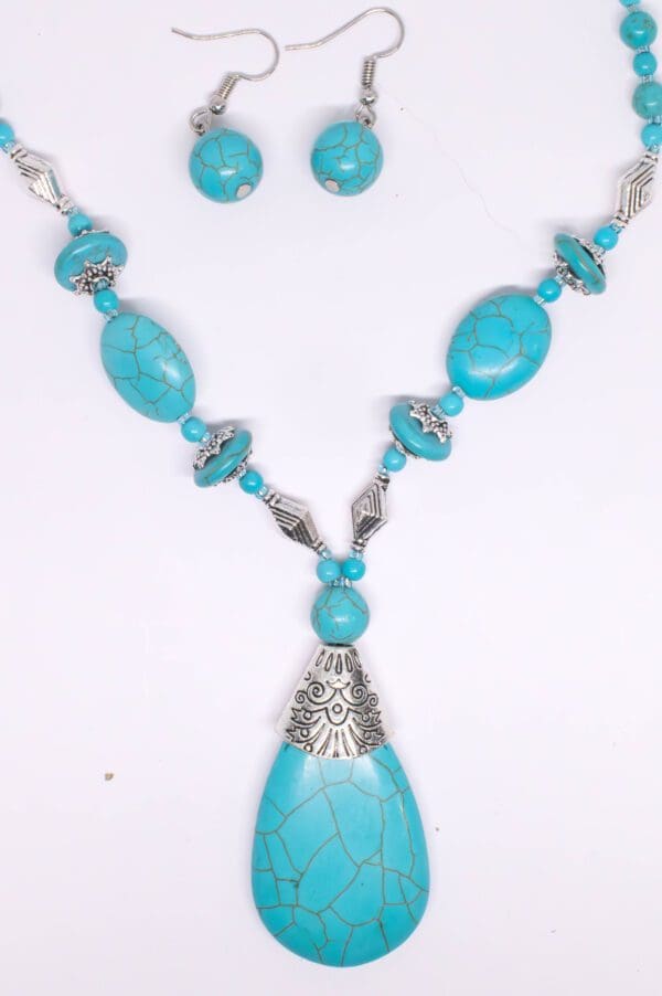 A turquoise necklace and earring set with silver accents.