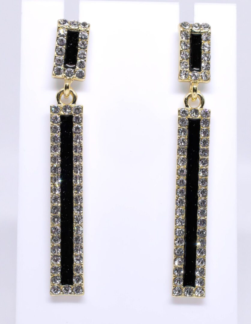 A pair of long earrings with black and clear stones.