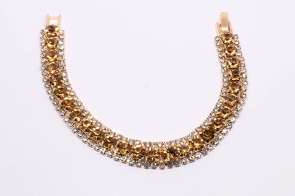 A gold chain with two rows of clear stones.