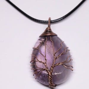 A necklace with an amethyst stone and wire tree of life.