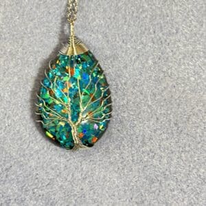 A tree of life necklace with green and blue colors.