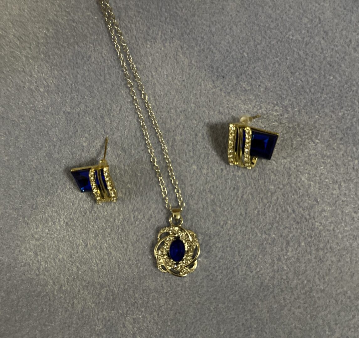 A necklace and earrings set with gold chains.