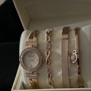 A watch and some bracelets are in a box