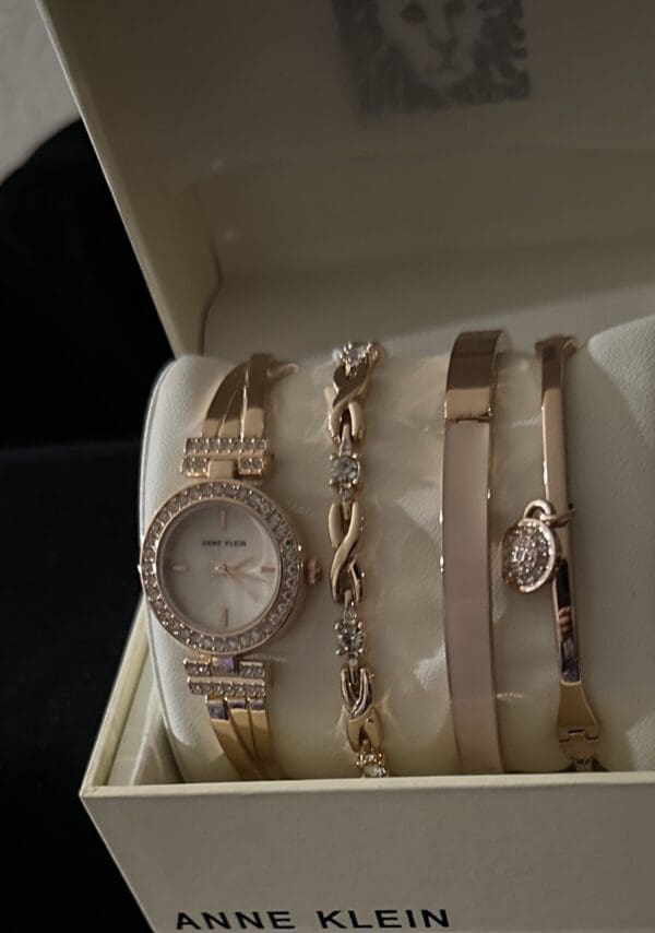 A watch and some bracelets are in a box