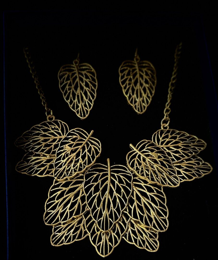 A necklace and earrings set with gold leaves.