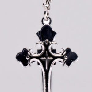 A cross with black and silver accents on a chain.