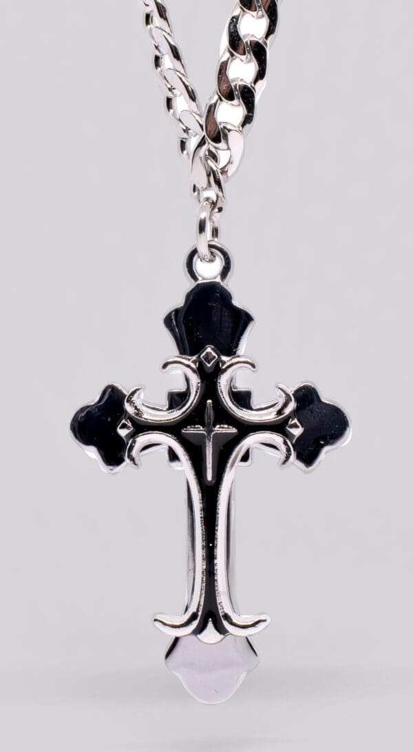 A cross with black and silver accents on a chain.