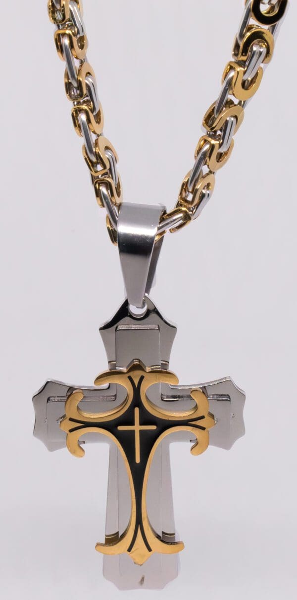 A cross with gold and black accents on a chain.