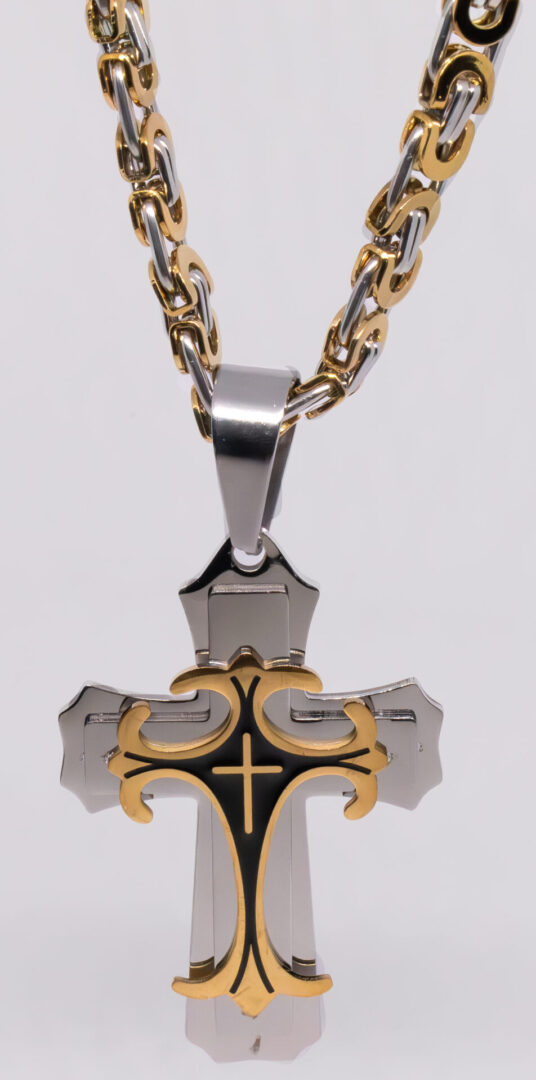 A cross with gold and black accents on a chain.