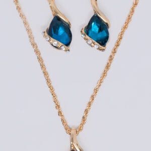 A gold chain necklace and earring set with blue stones.