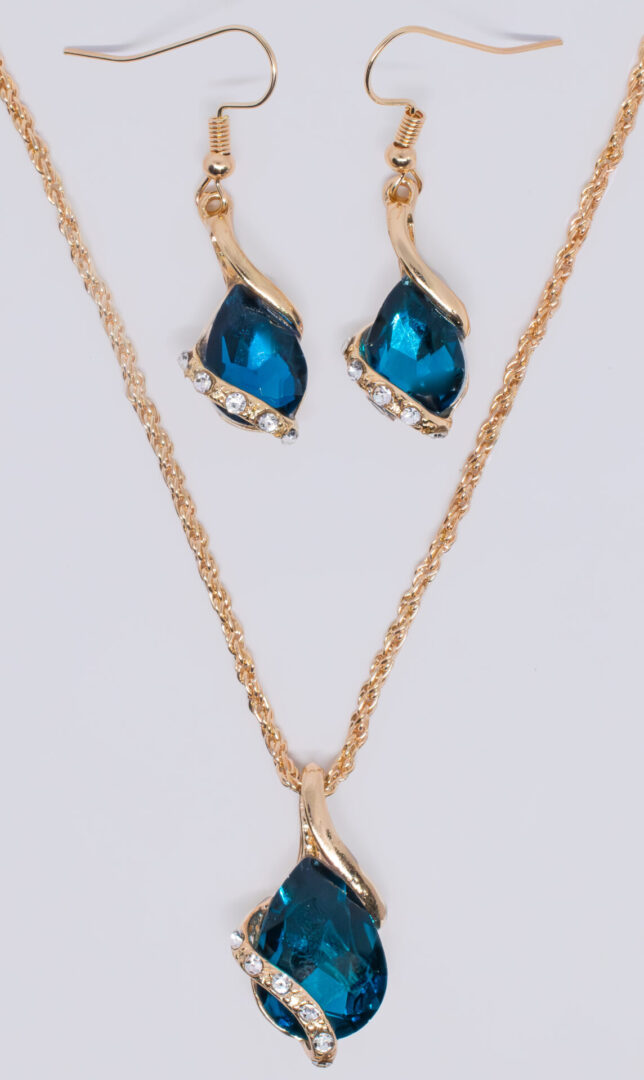 A gold chain necklace and earring set with blue stones.