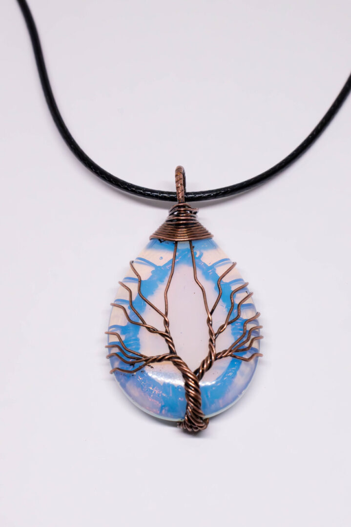 A blue and white tree of life necklace.