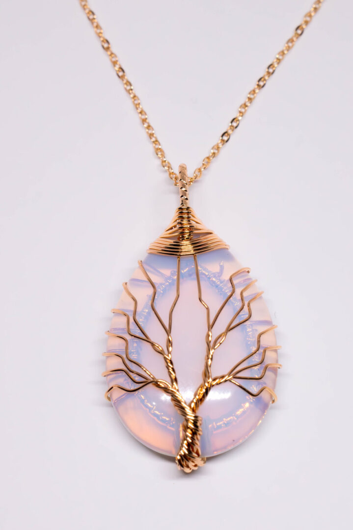 A tree of life necklace with a pink opal stone.